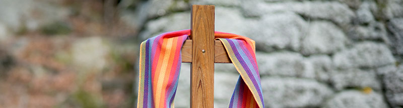 Ein Holzkreuz eingehüllt in einer bunten Stola